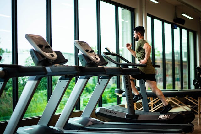 Person running on a treadmill inside of a fitness center